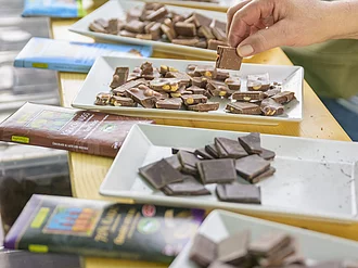Verschiedene Sorten Schokolade auf Probiertellern. Auf einem Tisch stehen kleine Probierteller mit verschiedenen Sorten Rapunzel Schokolade.