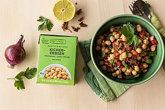 Gericht mit Kichererbsen – praktische Bio-Zutat im TetraPak Fertig zubereitetes Gericht mit Kichererbsen, daneben ein Rapunzel TetraPak – stimmungsvolle Food-Inszenierung mit Bio-Hülsenfrüchten.