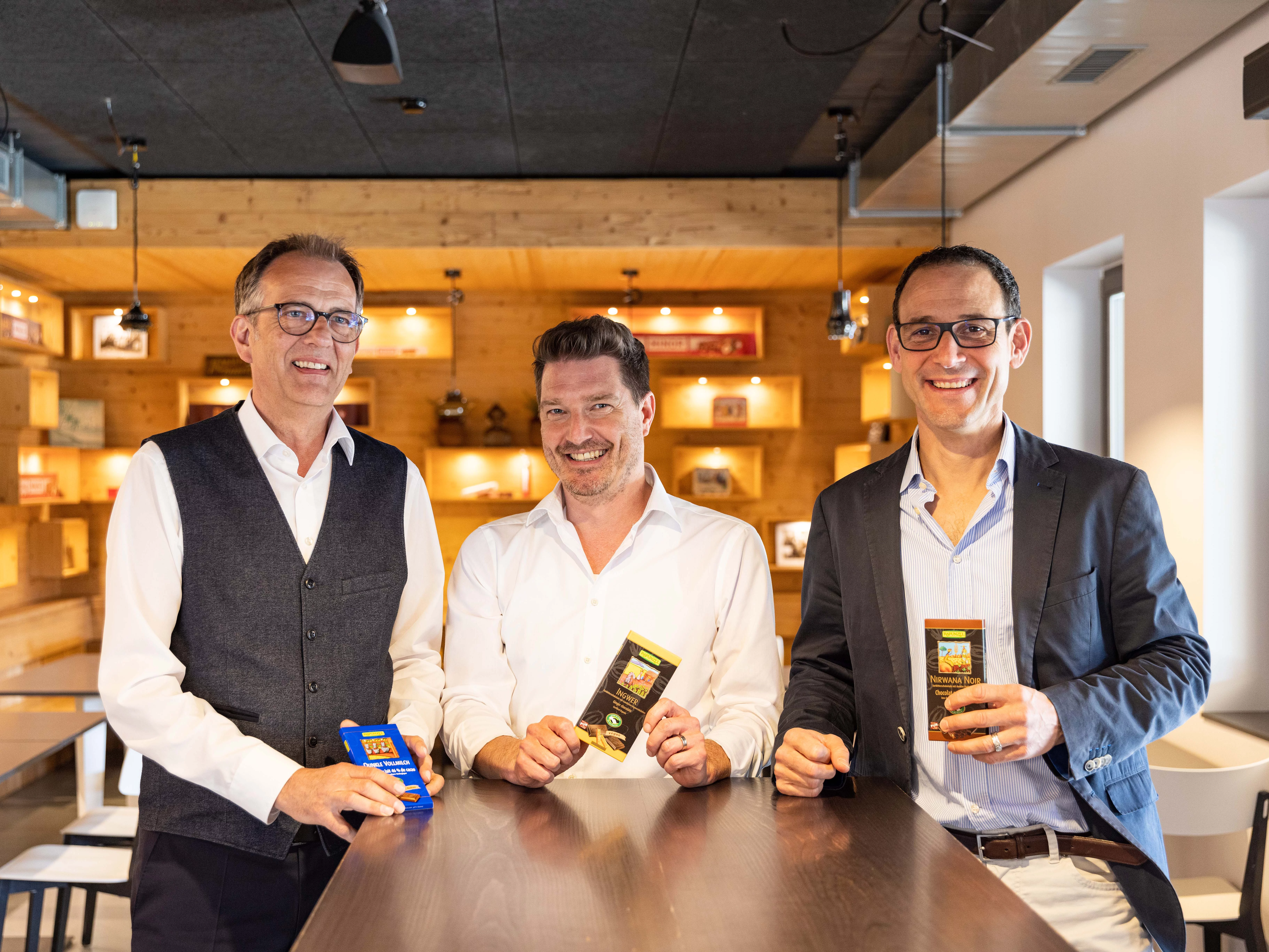 Günther Kscheschinski, Thomas Leitner und Christoph Birchler von Maestrani. Günther Kscheschinski, Thomas Leitner und Christoph Birchler halten Maestrani Schokoladen in die Kamera.