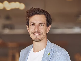 Leonhard Wilhelm, Geschäftsleitung und Gesellschafter Porträt von Leonhard Wilhelm. Er ist Geschäftsleitung und Gesellschafter. Das Foto zeigt ihn frontal, lächelnd und formell gekleidet. Der Hintergrund ist unscharf.