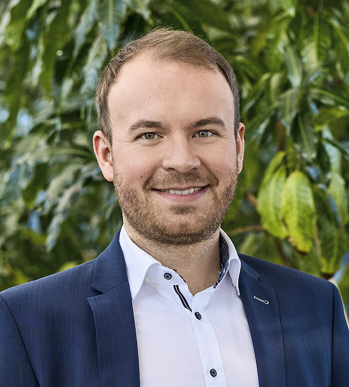 Felix Bartelt Mitarbeiter Rapunzel Presseteam vor Pflanzen.